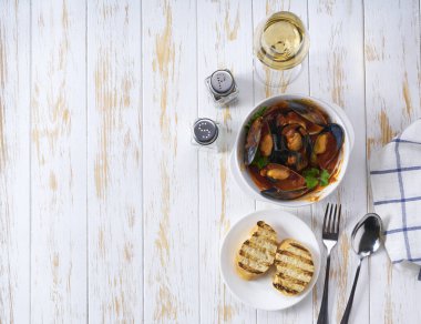 Domates soslu midye çorbası ve beyaz bir masada kızarmış ekmek..