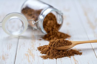 Tarçın tozu, beyaz ahşap bir masadaki saklama kavanozundan döküldü..