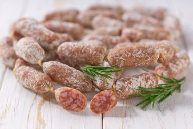Chorizo mini, baharatlı domuz mayalanmış kurutulmuş salam sosisleri ahşap bir masaya yakın..
