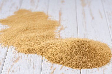 Aydınlık bir masada kuru amaranth, seçici bir odak. Kuru amaraniteyi bir ışık masasına yığın.