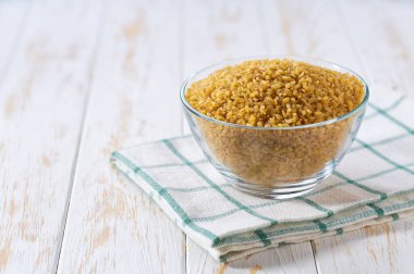 Açık bir cam kasedeki organik kuru bulgur, seçici bir odak noktası..