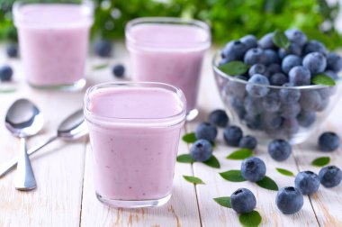 Cam kavanozlarda taze yaban mersinli ev yapımı meyveli yoğurt.