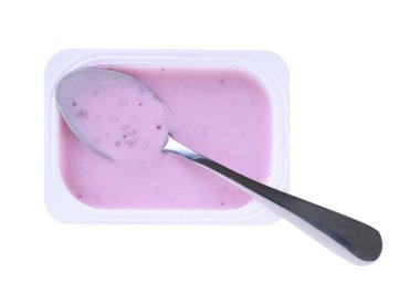 Beyaz arka planda izole edilmiş beyaz plastik bardakta kaşıklı yaban mersinli yoğurt veya meyve tatlısı..