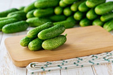 Kesme tahtasındaki organik salatalıklar, beyaz kithen masasında..