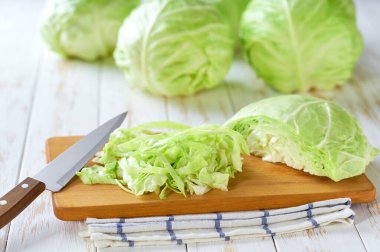 Kesme tahtasının üstünde dilimlenmiş yeşil lahana..