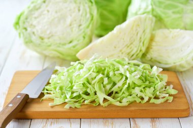 Beyaz ahşap bir masada taze taze, dilimlenmiş lahana..