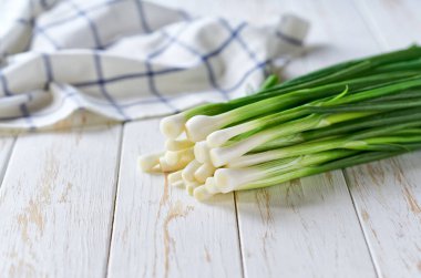 Taze taze soğan ya da soğan beyaz bir masada, seçici bir odak noktası..
