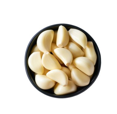 Soyulmuş sarımsak, beyaz arka planda izole edilmiş siyah bir kasede..