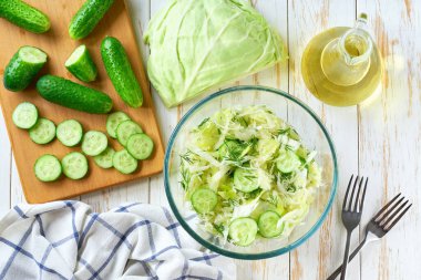 Vejetaryen salatası. Lahana, salatalık ve dereotlu bahar vejetaryen salatası. Üst manzara, düz yatak, genel giderler. Vejetaryen ya da diyet yemekleri..