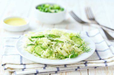 Tahta bir masada taze sebze salatası, salatalık ve dereotu..