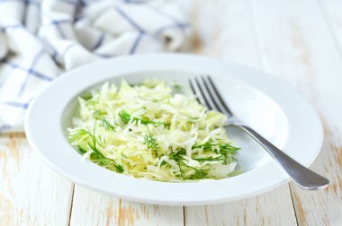 Tahta bir masada sağlıklı sebze salatası, salatalık ve dereotu..