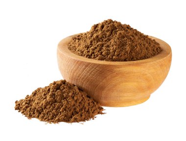 Tahta bir kaseden dökülen organik tarçın tozu beyaz bir arka planda izole edilmiş..