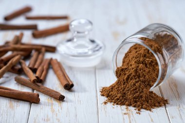 Tarçın tozu, beyaz ahşap bir masadaki saklama kavanozundan döküldü..