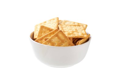 Beyaz arka planda izole edilmiş bir tabakta tuzlu ya da kare kraker. Çorba krakerleri izole bir tabakta. İzole edilmiş bir tabakta buğday suyu krakerleri..