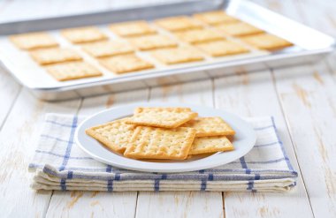 Fırın tepsisini beyaz bir masada buğday bisküvileriyle kapat..