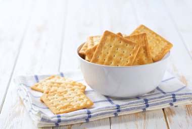 Lezzetli buğday bisküvileri tabakta kare şeklinde ve açık mutfak masasında seçici bir odak noktası var..