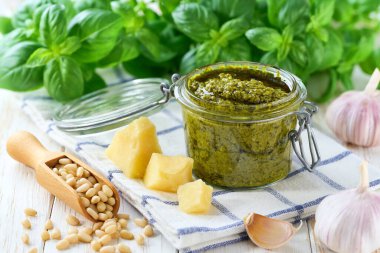 Kavanozda pesto sosu ve beyaz masa malzemeleri. Pesto - geleneksel İtalyan sosu fettuccine, Focaccia, pizza.