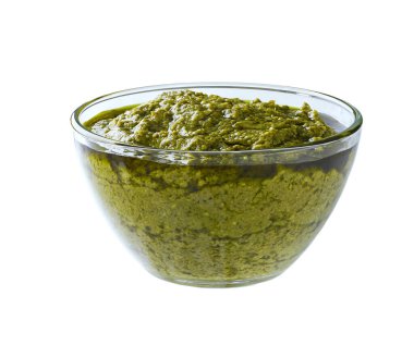 Beyaz arka planda izole edilmiş cam bir kasede geleneksel İtalyan sosu pesto..