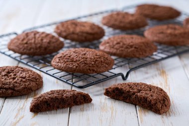 Geleneksel çikolatalı kurabiyeler beyaz bir masadaki rafta pişirildikten sonra soğur..