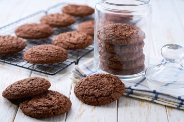 Bir kavanoz dolusu lezzetli çikolatalı kurabiye beyaz bir masada, metin için fotokopi alanı var..