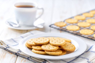 Açık mutfak masasında kuru kraker, kurabiye ve kahve, seçici odak.