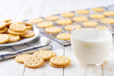 Beyaz bir masada lezzetli yuvarlak krakerler ve süt, yakın..