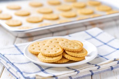 Beyaz bir masada tuzlu krakerle pişirme tepsisini kapat..