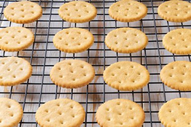 Siyah tel askıda soğuyan tuzlu krakerler ve açık mutfak masası..