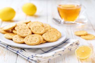 Geleneksel buğday yuvarlak krakerler ve açık mutfak masasında çay, seçici bir odak.