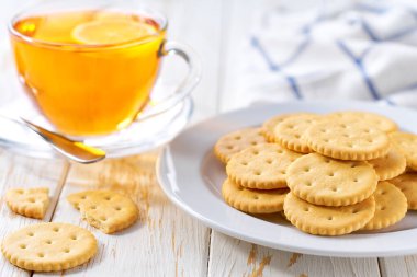 Beyaz bir masada buğday yuvarlak kraker ve çay, seçici bir odak..
