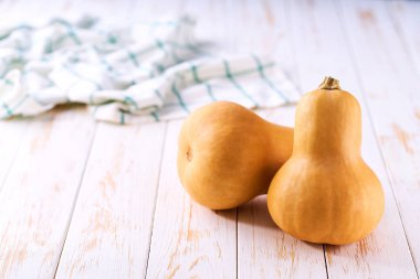 Şişe şeklinde tereyağlı balkabağı açık ahşap bir masada, seçici bir odak.