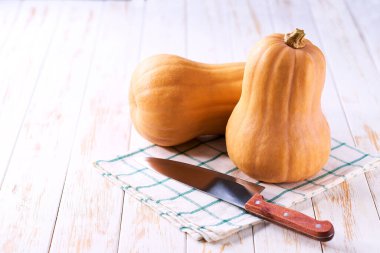 Şişe şeklinde tereyağlı balkabağı açık ahşap bir masada, seçici bir odak.