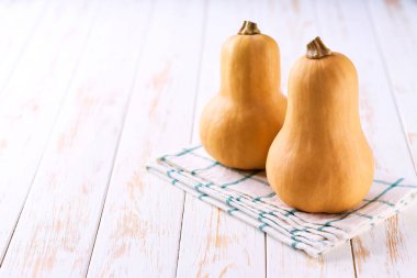 Şişe şeklinde tereyağlı balkabağı açık ahşap bir masada, seçici bir odak.