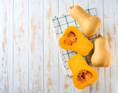 Açık ahşap bir masada tereyağı şeklinde bir balkabağı şişesi, metin için opi alanı. Üst görünüm.