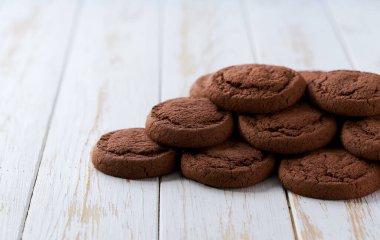 Mutfak masasında bir yığın lezzetli çikolatalı kurabiye, metin için de fotokopi alanı var..