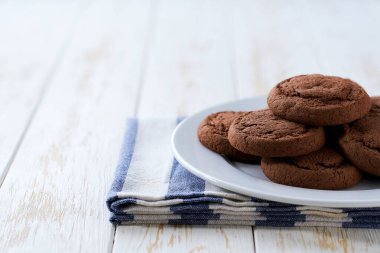 Tabakta lezzetli çikolatalı kurabiyeler ve açık mutfak masası, seçici bir odak..