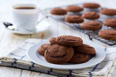 Çikolatalı kek ve kahve beyaz bir masada, seçici bir odak noktası..