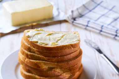 Tereyağlı ekmek dilimleri. Mutfak masasının üzerinde..