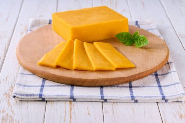 Açık mutfak masasında dilimlenmiş çedar peyniri, seçici bir odaklanma..