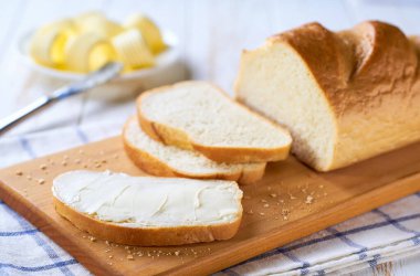 bir dilim buğday ekmeğine tereyağı sür kesme tahtasına, seçici odaklanma.