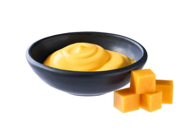 Bir kase lezzetli çedar sosu ve beyaz arka planda izole edilmiş peynir küpleri..