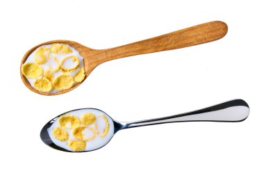 Beyaz arka planda izole edilmiş metal kaşıkta sütlü mısır gevrekleri..