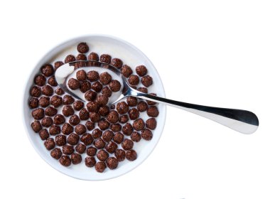 Sağlıklı kahvaltı, beyaz arka planda izole edilmiş sütlü bir kase çikolatalı mısır topu. Üst görünüm.