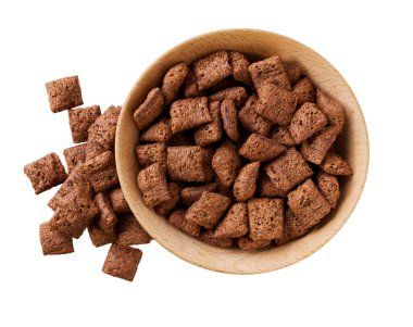 Beyaz arka planda izole edilmiş ahşap kaseden dökülen çikolatalı mısır pedleri. Üst görünüm.