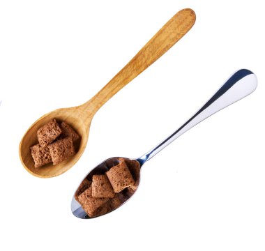 Beyaz arka planda izole edilmiş tahta kaşıkta çikolatalı yastıklar, üst manzara. Beyaz arka planda izole edilmiş gevrek kakao yastıkları..