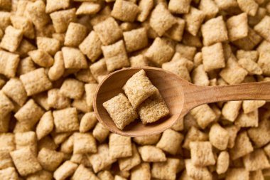 Arkaplan olarak mısır gevreğinden yapılmış ahşap bir kaşık içindeki lezzetli mısır gevrekleri. Metin için alanı kopyala.