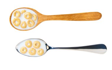 Yuvarlak yulaf esaslı mısır gevreği, beyaz arka planda izole edilmiş süt, üst manzara. Bir kaşık mısır gevreği ve süt izole edilmiş..