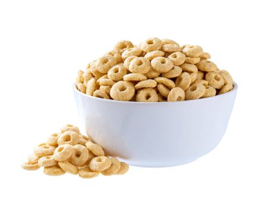 Yuvarlak yulaf tabanlı mısır gevreği beyaz arka planda izole edilmiş seramik tabaktan dökülüyor. Gevrek yulaf gevreği döngüleri dökülüyor.