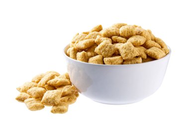 Beyaz arka planda izole edilmiş seramik tabaktan mısır yastıkları dökülüyor. Çıtır mısır gevrekleri dökülüyor.