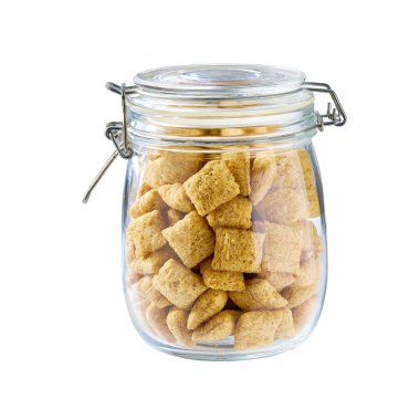 Beyaz arka planda izole edilmiş cam bir kavanozdaki lezzetli mısır tabletleri..